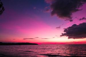 mooi zonsondergang over- de zee Aan roze lucht voor reizen en vakantie foto