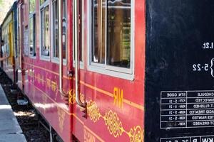 speelgoedtrein die zich op berghellingen beweegt, prachtig uitzicht, een zijberg, een zijvallei die zich op een spoorlijn naar de heuvel beweegt, tussen groen natuurlijk bos. speelgoedtrein van kalka naar shimla in india, indiase trein foto