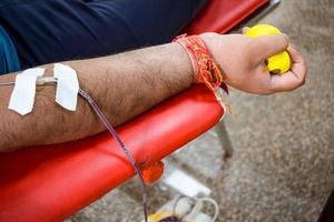 bloeddonor in bloeddonatiekamp gehouden met een springkussen in de hand in balaji-tempel, vivek vihar, delhi, india, afbeelding voor wereldbloeddonordag op 14 juni elk jaar, bloeddonatiekamp foto