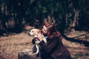 vrouw omarmen hond in Woud foto