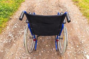 lege rolstoel die op de weg staat te wachten op patiëntendiensten. rolstoel voor mensen met een handicap buiten geparkeerd. toegankelijk voor personen met een handicap. gezondheidszorg medisch concept. foto