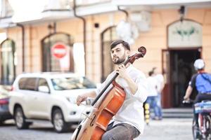 man die cello speelt op straat in de zomer foto