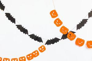 truc of traktatie concept. vakantie samenstelling met halloween slinger decoraties pompoenen en vleermuizen geïsoleerd Aan wit achtergrond. voorbereiding voor halloween feest. herfst vallen gelukkig halloween foto
