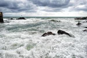 zee in storm Aan rotsen kust foto