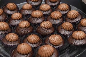 rij chocola taart in pannen met room Aan top foto