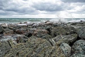 zee in storm Aan rotsen kust foto