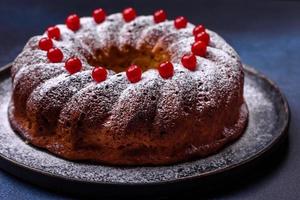 eigengemaakt heerlijk ronde Kerstmis taart met rood bessen Aan een keramisch bord foto