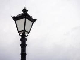 een mooi straat lamp Aan een achtergrond van een grijs lucht. foto