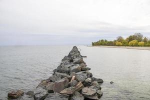 rotsachtig steiger gaan uit in de oceaan foto