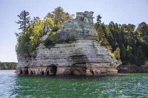 kleurrijk steen rotsen Aan de rand van een meer in de zomer foto