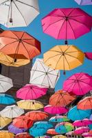 laag hoek visie van kleurrijk paraplu's hangende Aan kabels temidden van stad in zomer foto