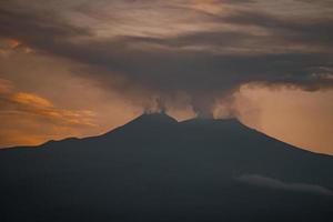 toneel- visie van rook emitting van vulkanisch monteren Etna gedurende zonsondergang foto