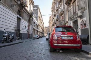 auto's en scooter geparkeerd Aan straat kant temidden van oud gebouwen in stad foto