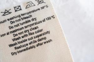 wasserij zorg het wassen instructies kleren etiket Aan kleding stof structuur achtergrond foto