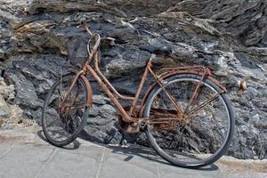 verroest fiets Aan rotsen achtergrond foto