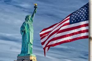 Verenigde Staten van Amerika Amerikaans vlag sterren en strepen Aan standbeeld van vrijheid blauw lucht achtergrond foto