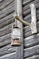 olie lamp Aan houten hut achtergrond foto