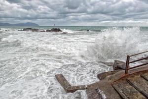 zee in storm Aan rotsen foto