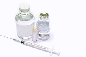 vaccin in flacon fles en 3 ml. ampul van drug en plastic injectiespuit zetten in een medisch naald- Aan wit achtergrond. foto