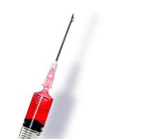 rood vaccin in plastic injectiespuit met een medisch naald- isoleren Aan wit achtergrond. maken met pad. foto