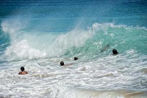 kinderen spelen in zee golven in Hawaii foto