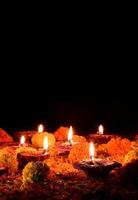 diya-lampen van klei steken een zwarte achtergrond aan tijdens diwali-viering foto