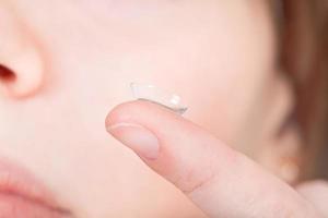 contact lens Aan vinger in de buurt vrouw gezicht foto