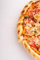halve pizza op witte houten achtergrond voor exemplaarruimte foto