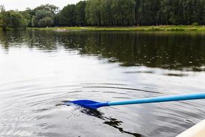 vlotter Aan boot met roeispanen in stad vijver foto