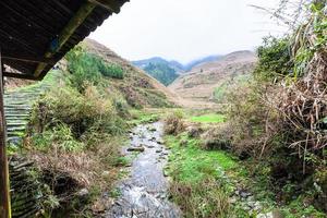 kreek tussen terrasvormig heuvels van dazhai dorp foto