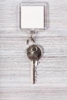 sleutel met wit blanco sleutelhanger Aan hout tafel foto