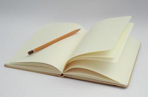 wit notitieboekje en geel potlood foto