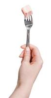 hand- Holding dineren vork met stuk van reuzel foto