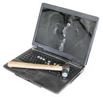 oud beschadigd laptop met hamer Aan toetsenbord foto