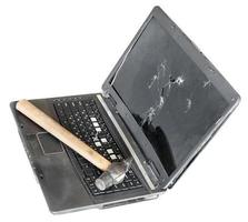 oud gebroken laptop met hamer Aan toetsenbord foto