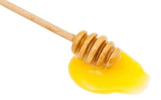 plas van geel honing en houten lepel dichtbij omhoog foto