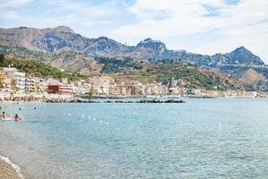 mensen in zee in de buurt waterkant van giardini naxos foto