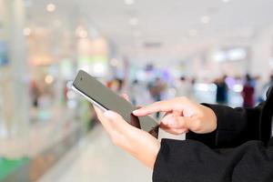 shopper met behulp van mobiele telefoon voor afrekenen bij supermarkt foto