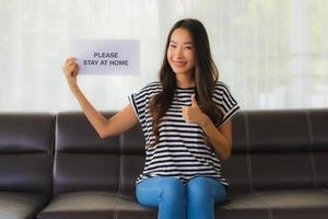 vrouw bedrijf teken om thuis te blijven geven duimen omhoog foto
