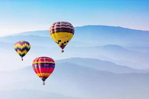 hete luchtballons die over bergen vliegen foto