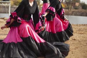 zigeuner dansen in helder jurken. meisjes dans Aan straat Spaans dans. helder kleding stof. foto
