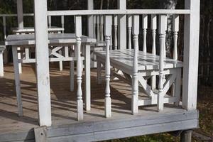 houten veranda Aan de straat. oud veranda in een land huis. de traliewerk is geschilderd wit. foto