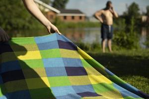 kom tot rust in zomer Aan strand. gekleurde deken Aan meer. details van picknick in park. foto