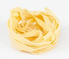 Italiaanse pasta fettuccine nest geïsoleerd op een witte achtergrond foto
