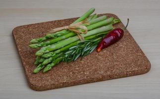 rauw asperges Aan houten bord en houten achtergrond foto