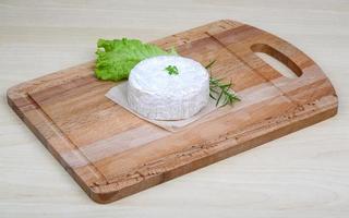 Camembert kaas Aan houten bord en houten achtergrond foto