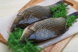 twee crucian Aan houten bord en houten achtergrond foto