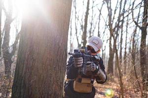 man van particulier militair bedrijf met geweer in het bos foto