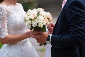close-up van bruid en bruidegom hand in hand foto