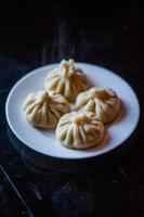 dim sum op plaat op donkere tafel foto